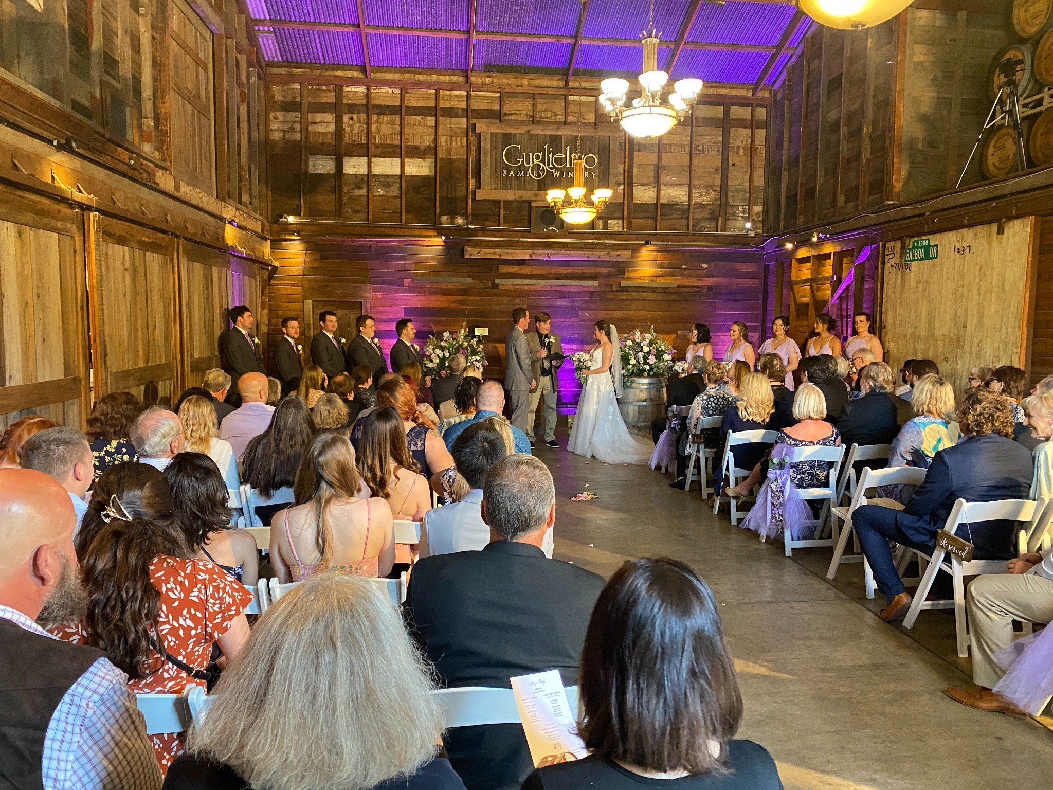 Wedding guests seated inside a rustic reception venue
